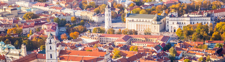 Panorama van de oude binnenstad van Vilnius met kathedraal en klokkentoren in herfstkleuren.