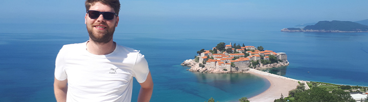 Joran met zonnebril bij uitzicht op Sveti Stefan en de Adriatische Zee in Montenegro.