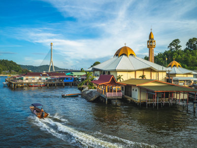 Moskee aan de rivier in Bandar Seri Begawan, Brunei, met boot op het water en brug op de achtergrond.