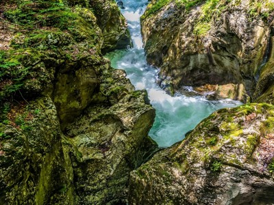 Groene kloof met helderblauw rivierwater en rotsen langs de Route Slovenië.