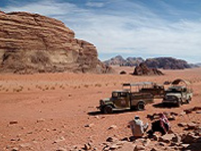 Jeepsafari door de Wadi Rum-woestijn in Jordanië, met rotsformaties op de achtergrond.