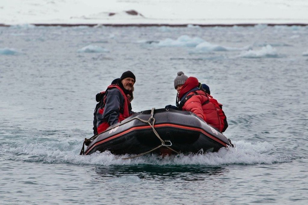 Reizigers in warme kleding op een zodiac tijdens een cruise rond Spitsbergen met zeilschip Noorderlicht.