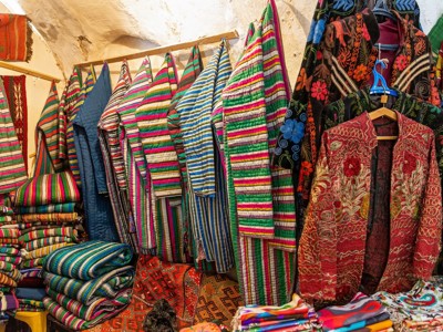 Kleurrijke Oezbeekse textiel en geborduurde jassen in een bazaar op de Route Oezbekistan.