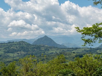Groene heuvels en bergen in Colombia onder een wolkenlucht, Route Colombia.