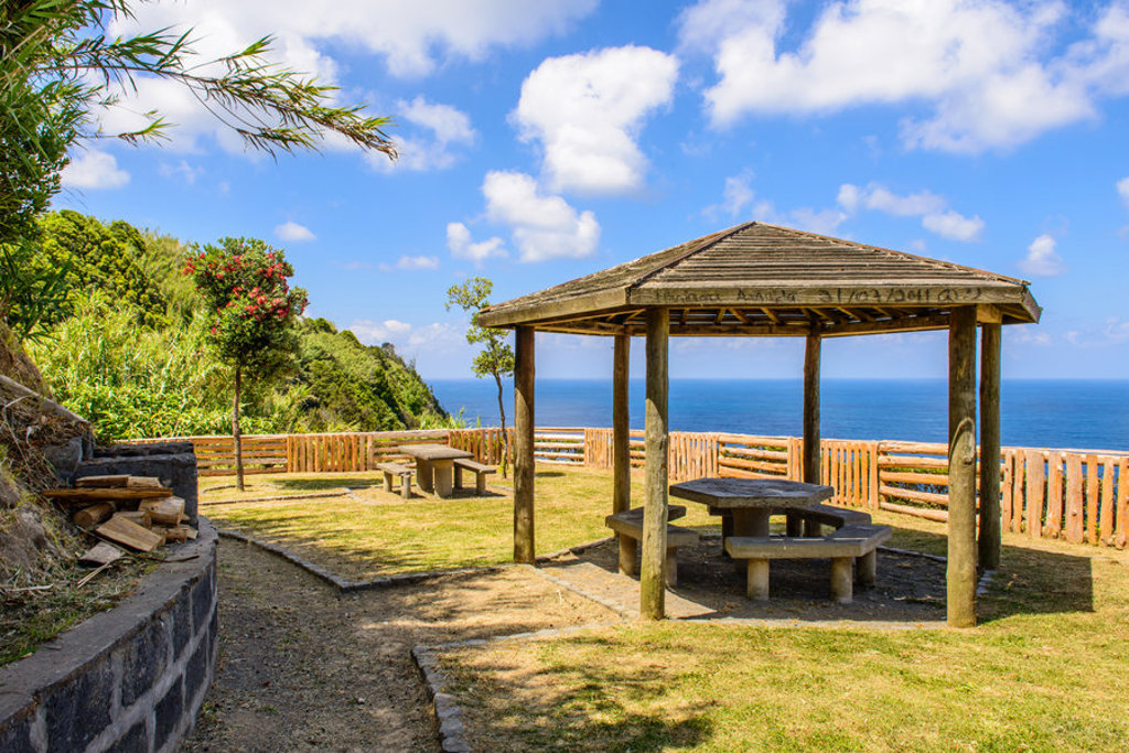 Picknickplaats met houten overkapping en uitzicht op de Atlantische Oceaan op de Azoren.