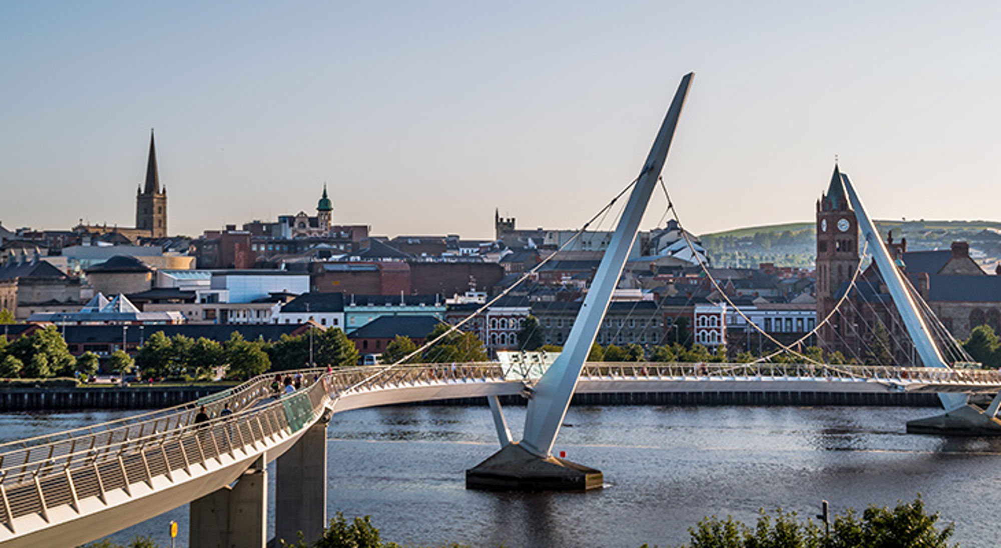 Peace Bridge, Londonderry, Noord-Ierland Peace Bridge over de River Foyle met skyline van Derry-Londonderry in Noord-Ierland.