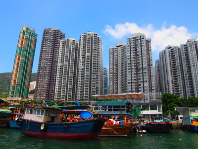 Vissersboten in de haven met hoge flatgebouwen op de achtergrond, China.