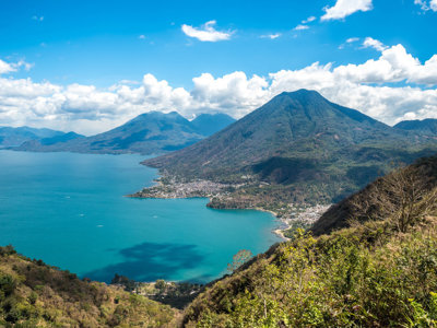 Uitzicht op het Atitlánmeer met vulkanen en dorpjes langs de oever in Guatemala.