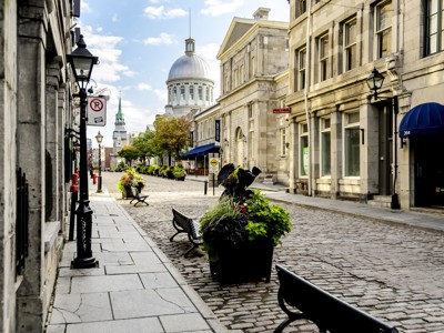 Kasseienstraat in Oud-Montréal met historische gebouwen en koepel op de achtergrond tijdens route Oost-Canada.