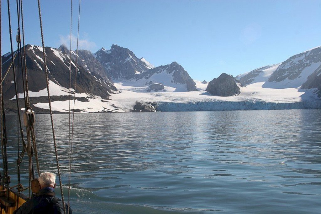 Zeilschip Noorderlicht tijdens groepsrondreis om Spitsbergen, met ijsbergen en arctisch landschap op de achtergrond.