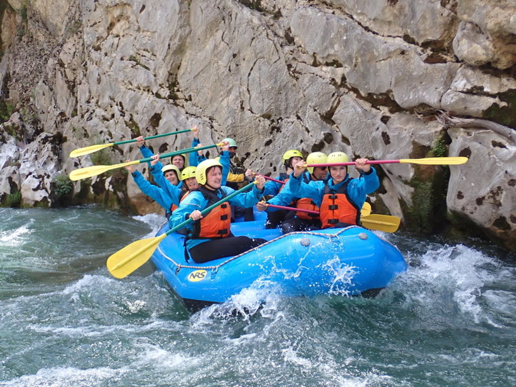 Raften door een kloof in Griekenland tijdens een 22-35ers reis, met groep in rubberboot op wildwater.