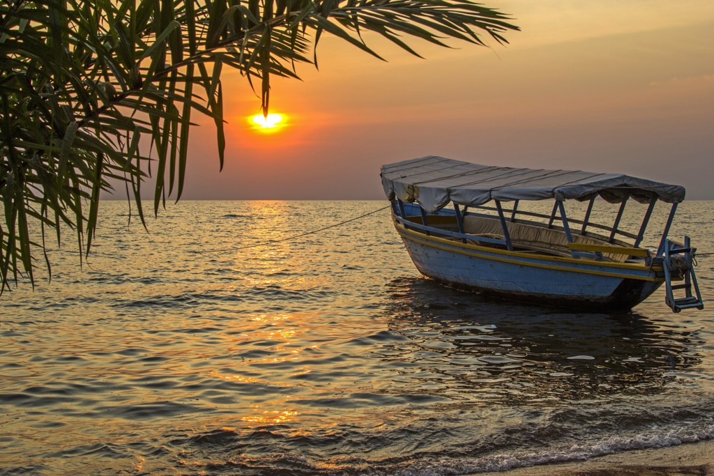 Bootje bij zonsondergang op het water tijdens een groepsrondreis Kenia en Tanzania.