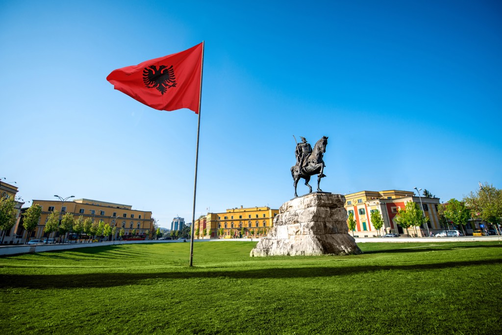 Albanese vlag en ruiterstandbeeld op Skanderbegplein in Tirana tijdens familiereis Albanië, Kosovo en Noord-Macedonië.