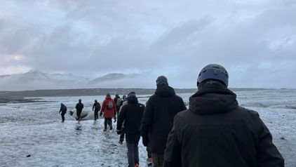 Groep wandelaars met helmen loopt over een gletsjer in IJsland tijdens een winterreis.