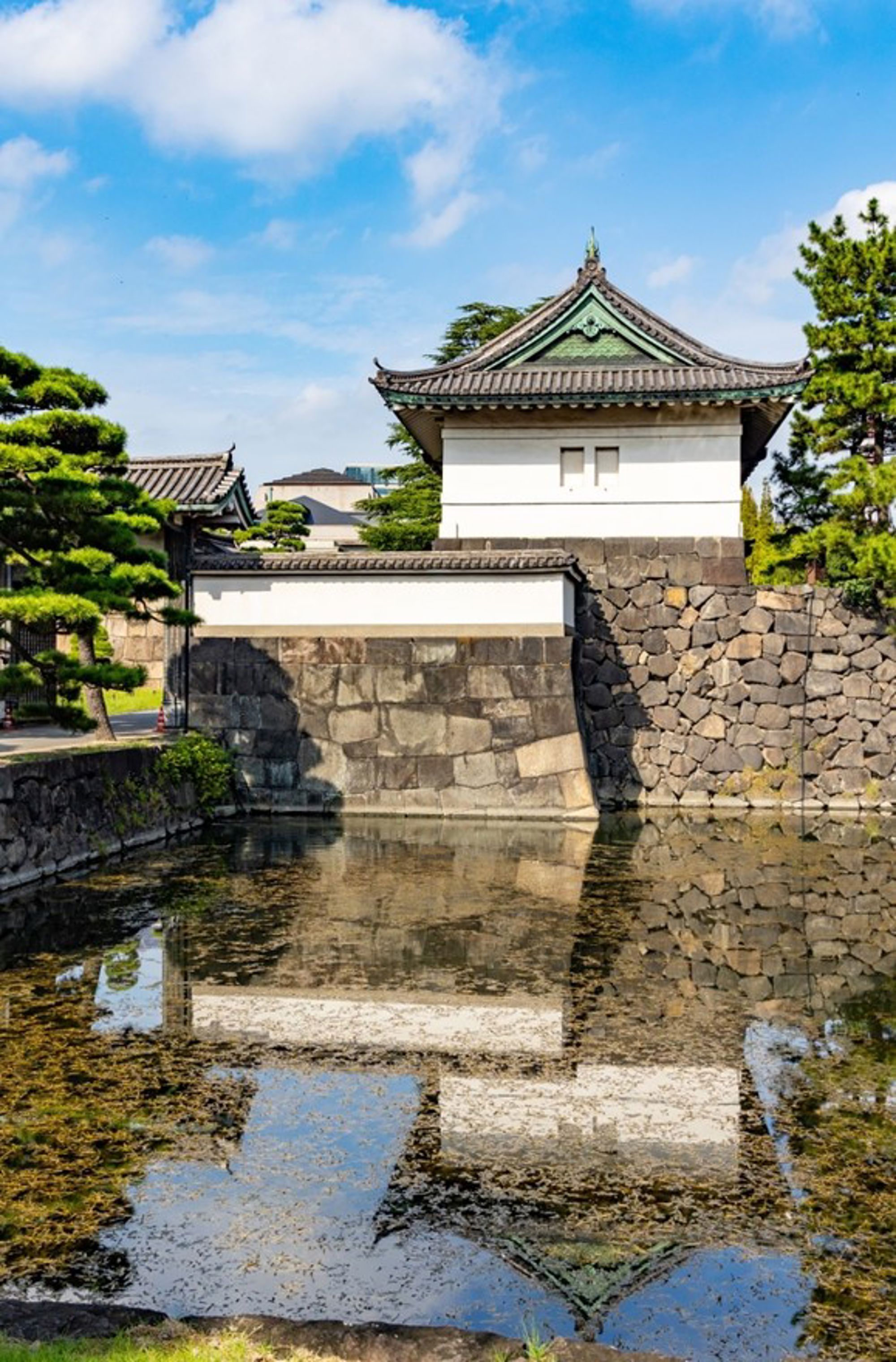 Verdedigingsmuur en wachttoren van het Keizerlijk Paleis in Tokio, Japan, met weerspiegeling in de gracht.