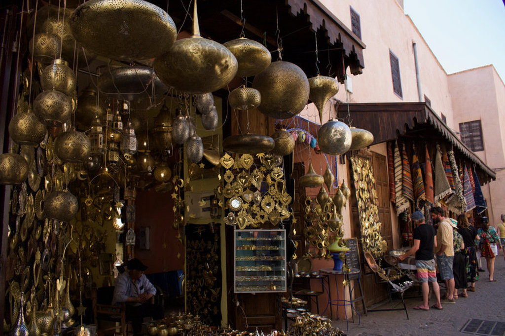 Souk in Marokko met hangende metalen lampen en tapijten, populair bezoek tijdens de premium groepsrondreis.