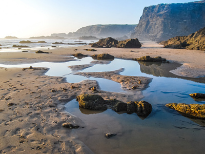 Rotsachtige kust met strand en getijdenpoelen langs de Costa Vicentina in Alentejo en Algarve, Portugal.