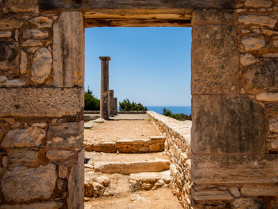 Uitzicht door stenen poort op oude ruïnes en zuilen met de Middellandse Zee bij Limassol, Cyprus.