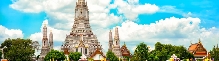 Wat Arun-tempel aan de Chao Phraya-rivier in Bangkok, met boot op de voorgrond.
