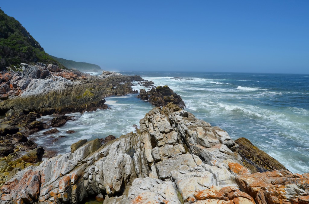 Rotsachtige kustlijn met beukende golven langs de Garden Route tussen Johannesburg en Kaapstad.