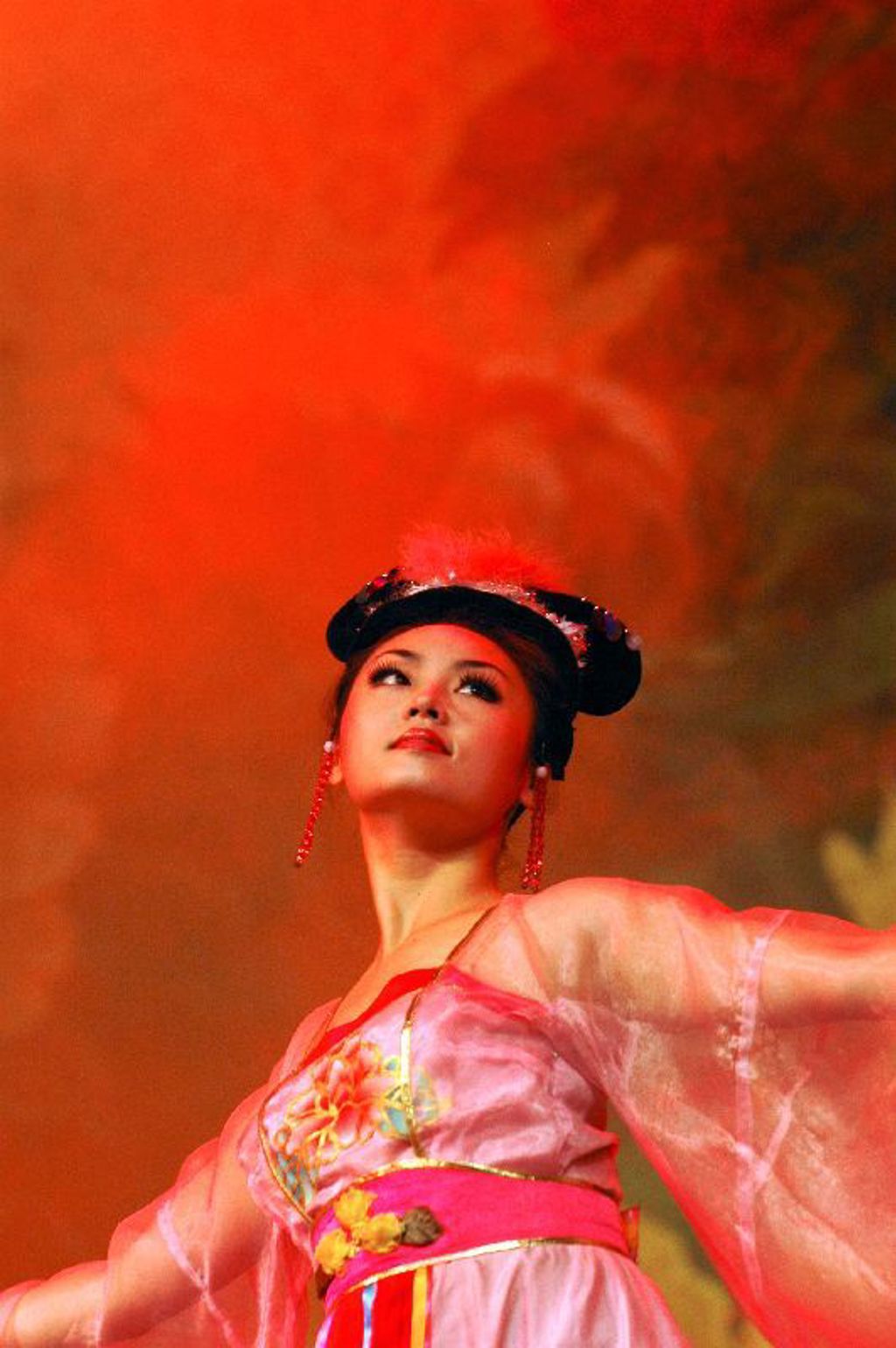 Chinese danseres in traditionele roze kleding tijdens een show op familiereis China.