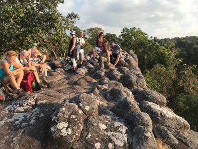 Wandelaars rusten op rotsen met uitzicht over het groene landschap in Thailand tijdens de rondreis Thailand Avontuur.