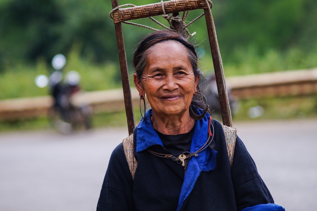 Portret van vrouw met draagmand langs de weg tijdens groepsrondreis China & Vietnam.