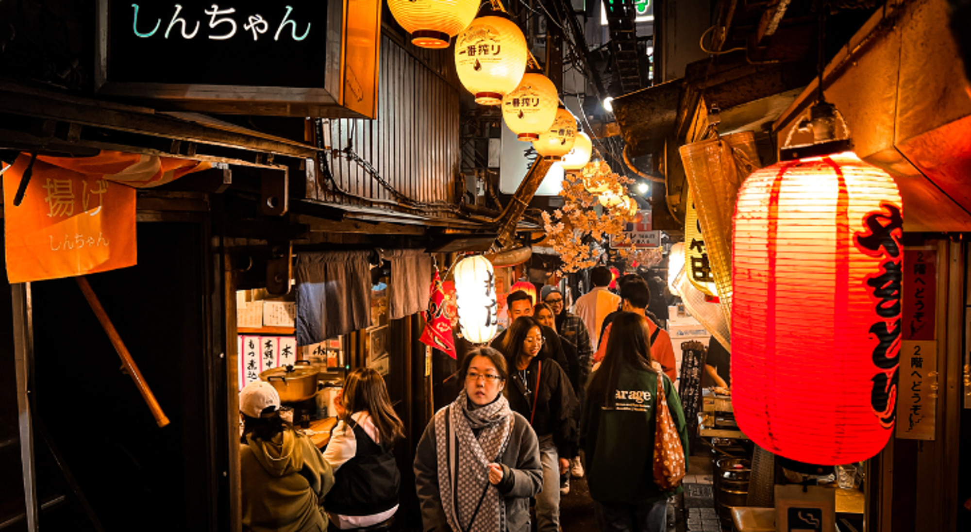 Memory Lane Drukke steeg met Japanse eetkraampjes en verlichte lantaarns in de avond.