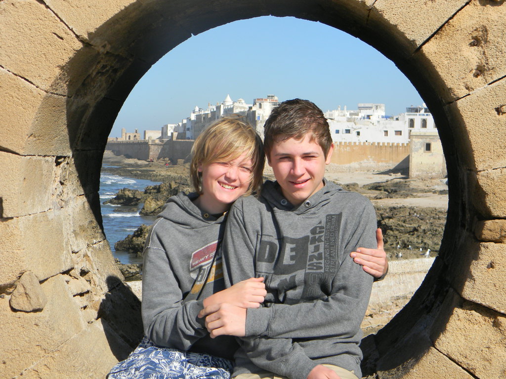 Twee jongeren poseren bij de kust van Essaouira tijdens Familiereis Marokko Zomer.