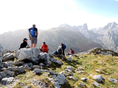Wandelaars rusten op rotsen met uitzicht op de bergen van Picos de Europa in Spanje.