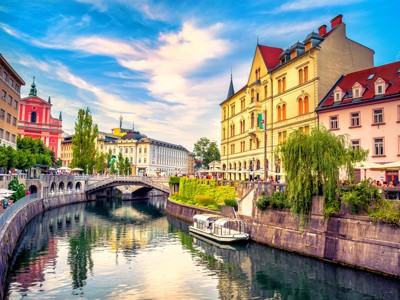 Uitzicht op de Ljubljanica in Ljubljana met brug, kleurrijke gevels en terrasjes langs de kade.