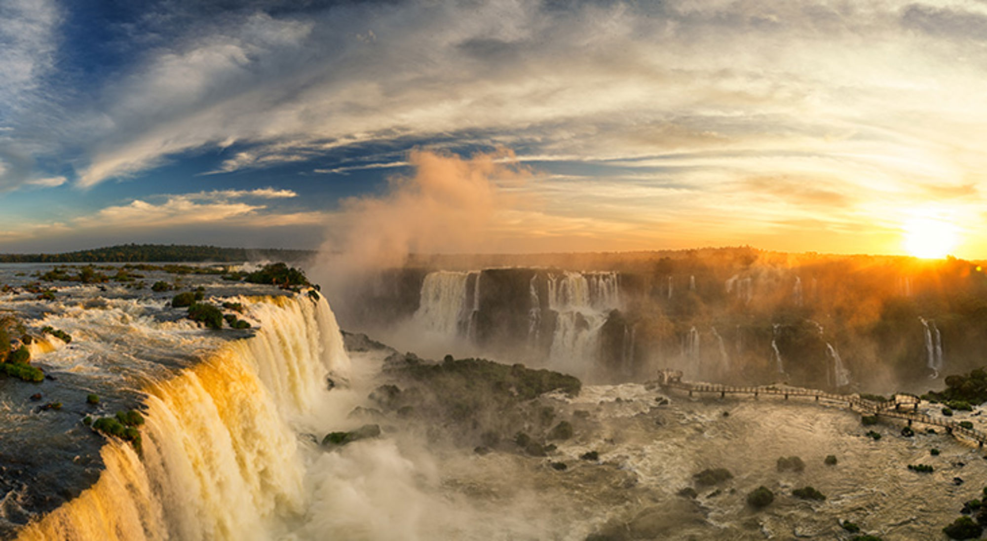Iguaza watervallen Iguazú-watervallen in Argentinië bij zonsondergang, met nevel boven de brede watervallen.