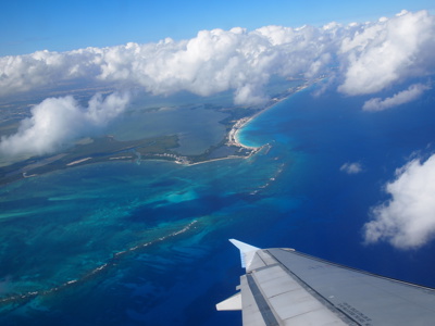 de Caribische kust bij Cancún, Mexico, met turkoois water en een vliegtuigvleugel op de voorgrond.
