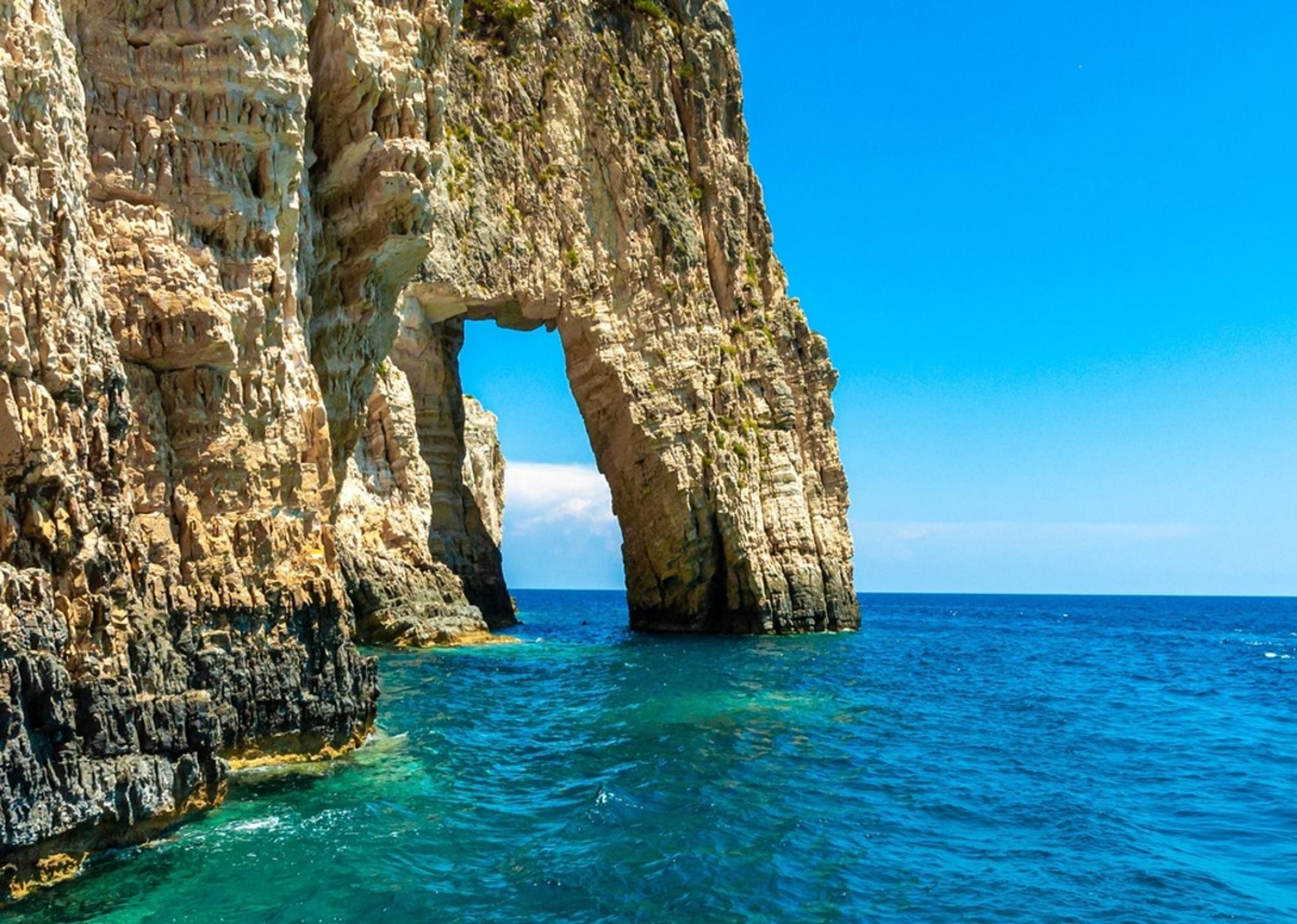 Rotsboog in een klif aan de turquoise zee bij Zakynthos, Griekenland.