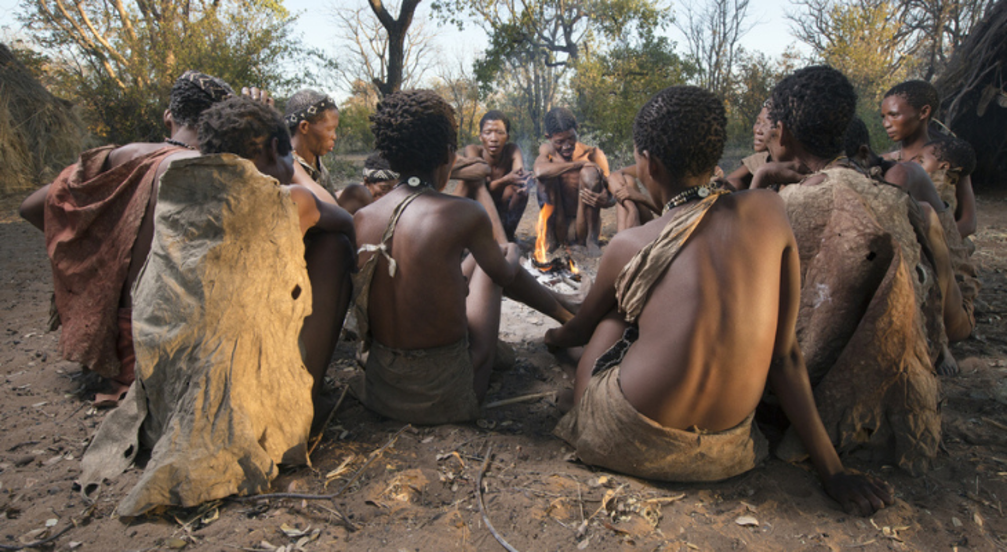 Grashoek in Namibië Groep mensen zit rond een kampvuur in een dorp in Namibië.