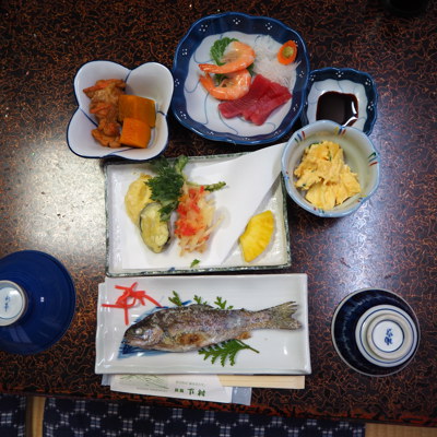 Traditionele Japanse maaltijd met gegrilde vis, sashimi en bijgerechten, geserveerd tijdens een groepsrondreis Japan.