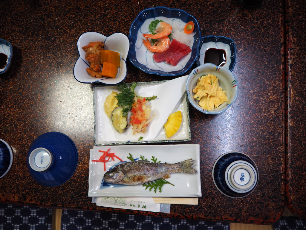 Traditionele Japanse maaltijd met gegrilde vis, sashimi en bijgerechten, geserveerd tijdens een groepsrondreis Japan.