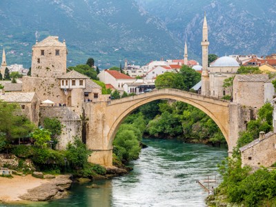 Stari Most in Mostar, iconische boogbrug over de Neretva met uitzicht op de oude stad en minaretten.