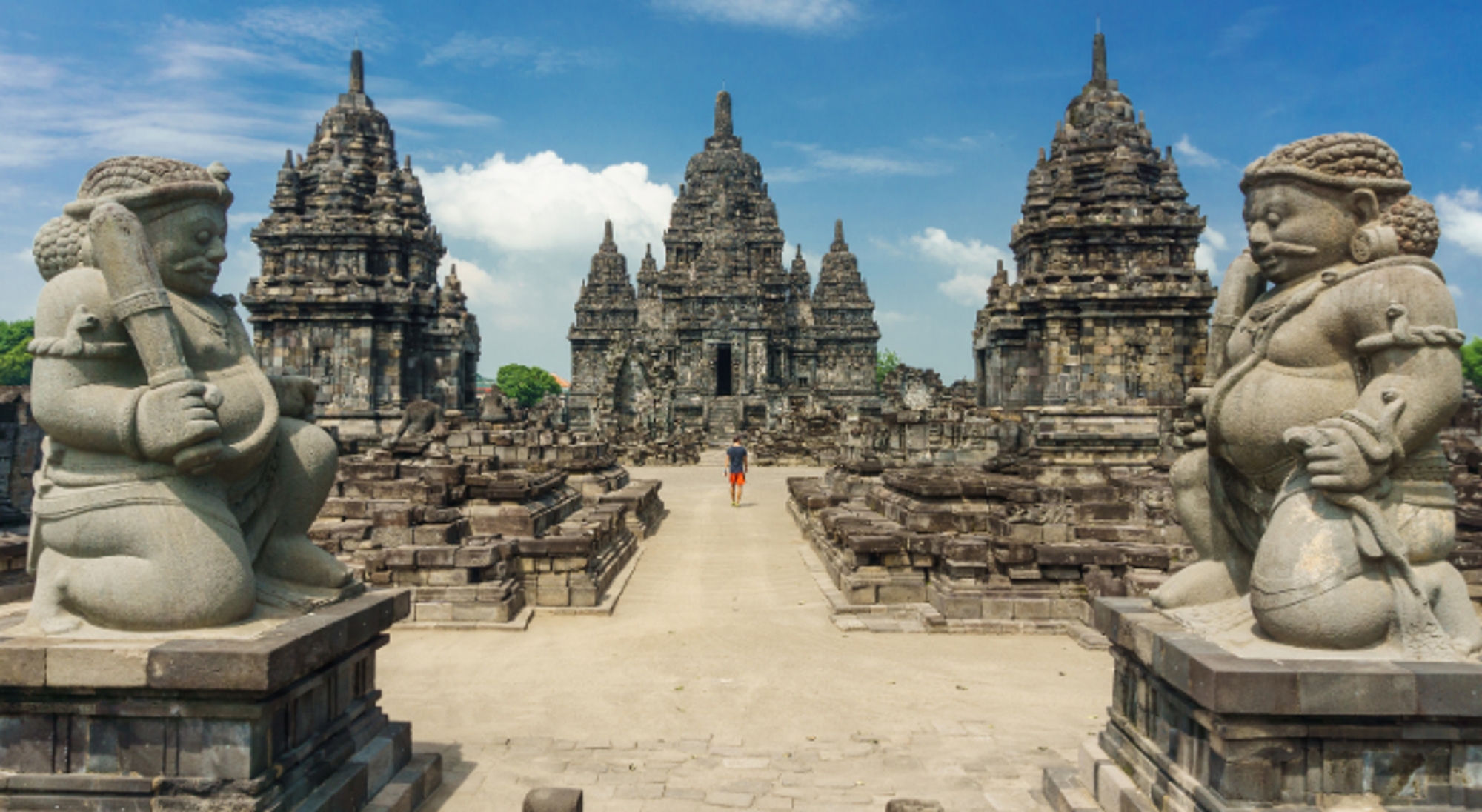 Sewu Tempel Java Tempelcomplex Prambanan op Java met stenen wachters en centrale tempeltorens onder een blauwe lucht.