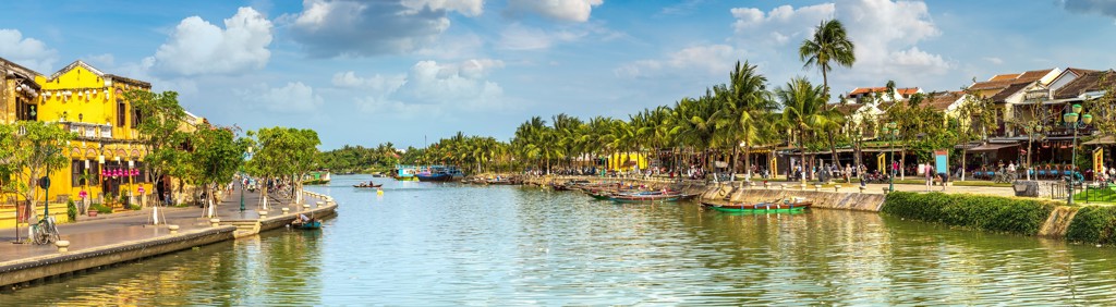 Rivier in Hoi An met kleurrijke boten, palmbomen en historische gevels tijdens een groepsrondreis Vietnam kort.