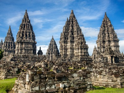 Prambanan-tempelcomplex op Java met hoge hindoeïstische torens onder een blauwe lucht.