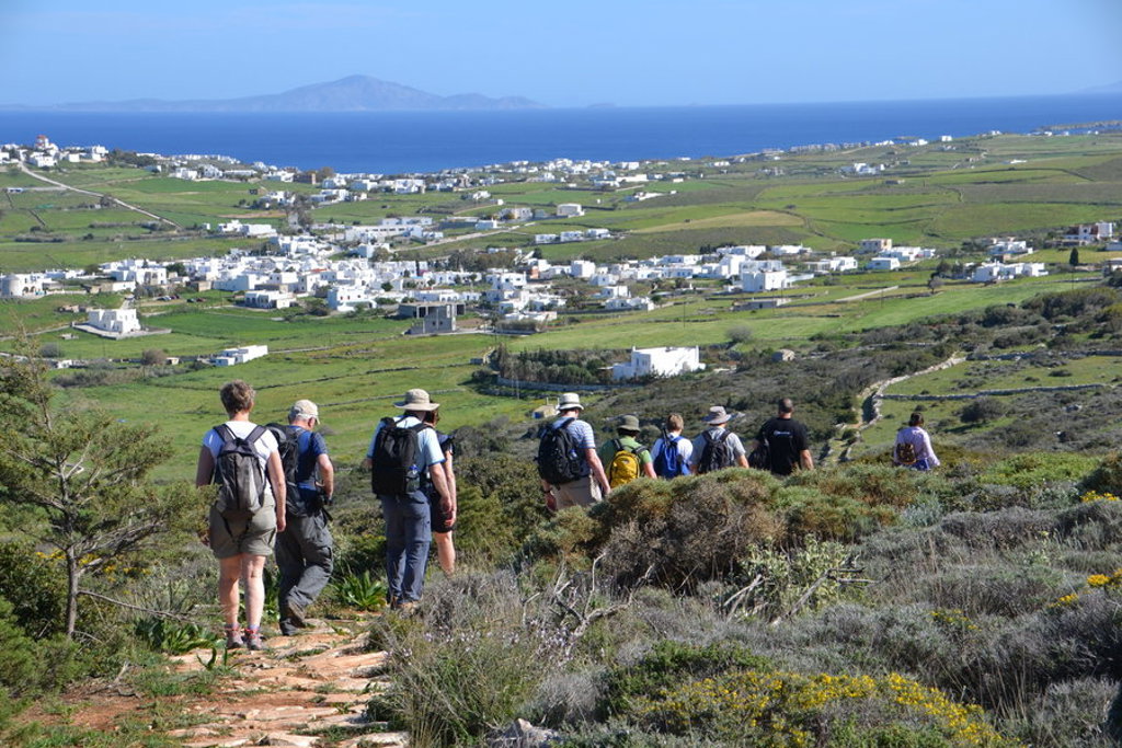 Wandelaars op Naxos met uitzicht op witte dorpjes, groene valleien en de Egeïsche Zee.