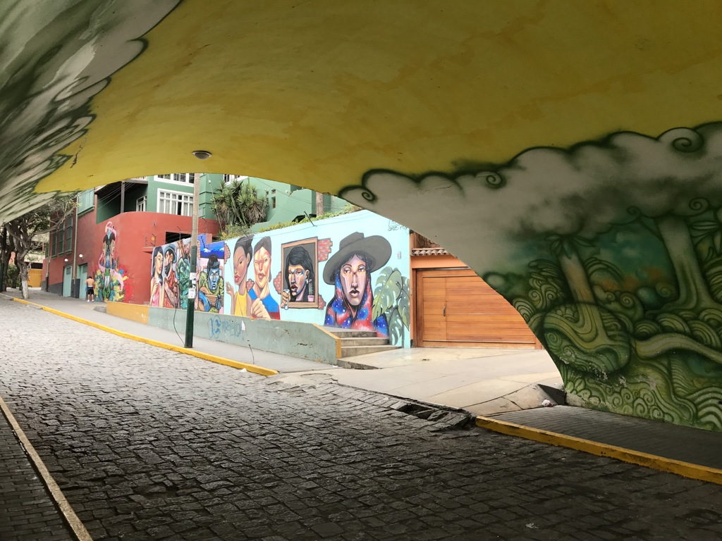 Straatkunst met kleurrijke muurschilderingen onder een tunnel tijdens een rondreis voor vrouwen in Peru.