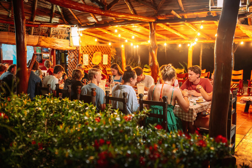 Gezellig diner met reizigers in een openluchtrestaurant tijdens een familiereis door Costa Rica.