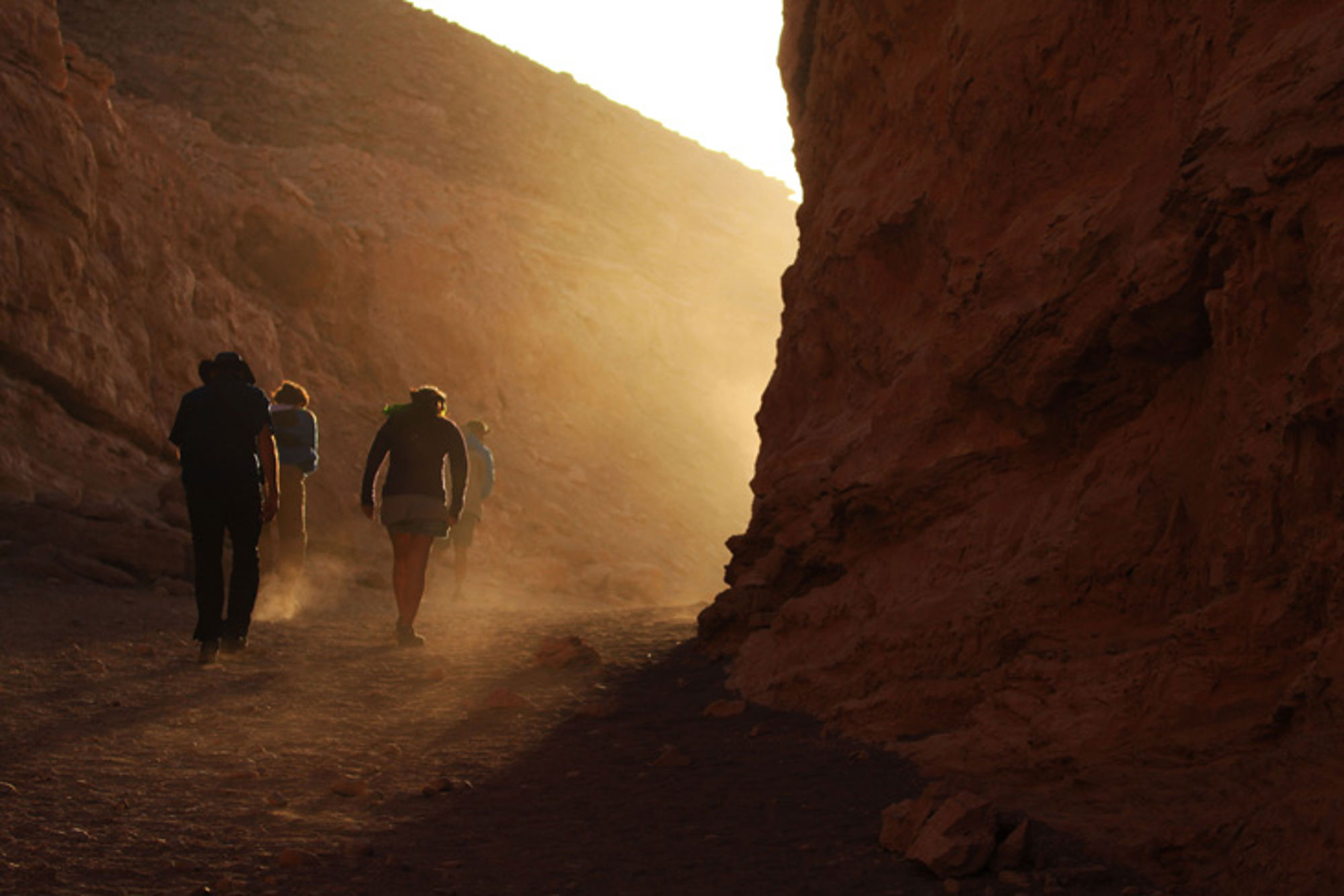 Atacama-woestijn, Chili Wandelaars lopen door een smalle rotscanyon in de woestijn bij laagstaande zon.
