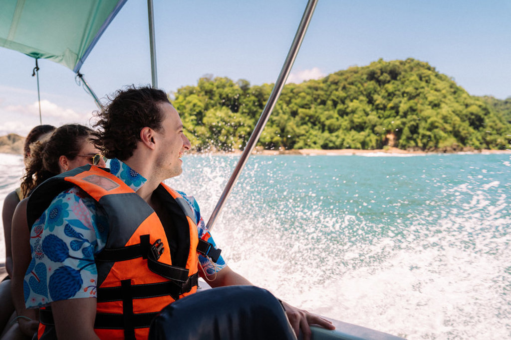 Jongeren op een speedboot langs de groene kust van Costa Rica tijdens een 22-35ers reis.