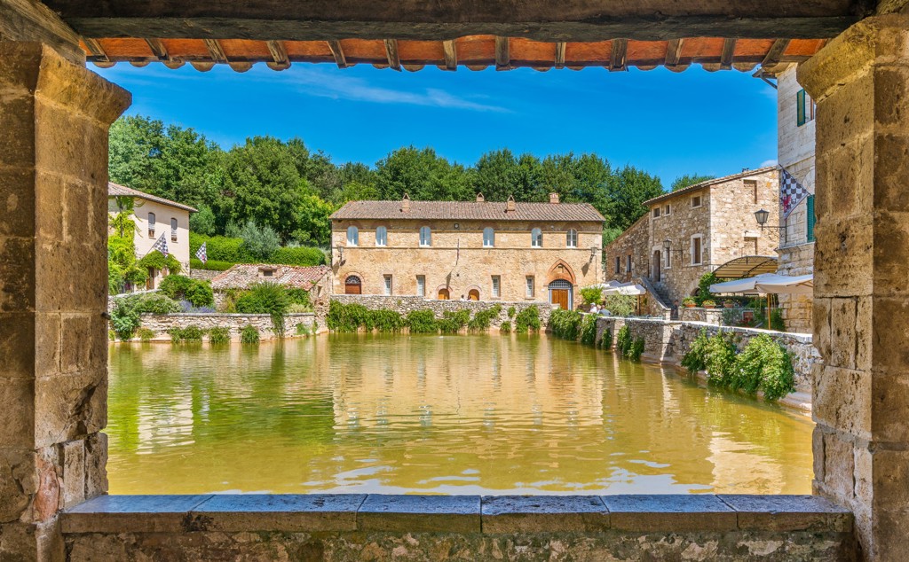 Uitzicht op de thermale bron Bagno Vignoni met Toscaanse stenen huizen in Italië.
