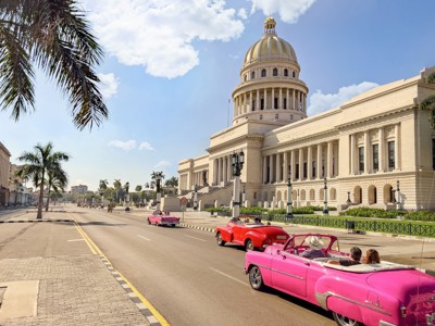 Oldtimers rijden langs het Capitool in Havana, Cuba.