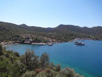 Baai aan de Turquoise Kust in Turkije met turquoise zee, groene heuvels en zeilboot bij de kust.