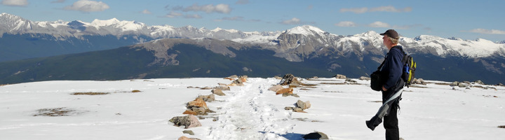 Wandelaar op een besneeuwd plateau met uitzicht op de Rocky Mountains in Canada (Arctic).